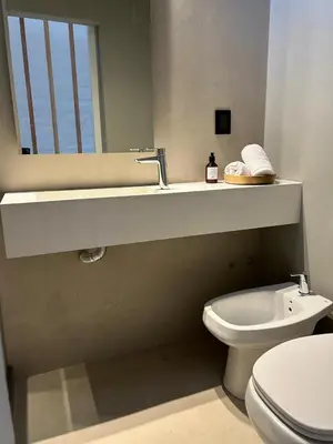 a bathroom with a toilet and a sink and a mirror at Duplex en el Cerro de Las Rosas by Lugar in Cordoba