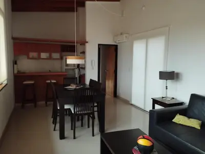 a living room with a couch and a table with chairs at Paraíso Serrano 16 in Villa Ciudad Parque