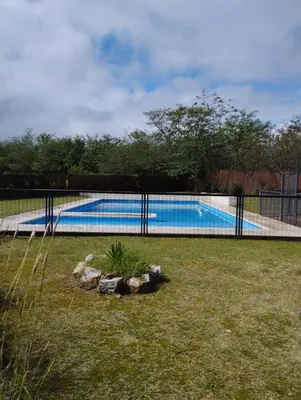 a swimming pool in a yard with a fence at Paraíso Serrano 16 in Villa Ciudad Parque