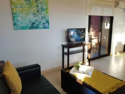 a living room with a couch and a tv at Paraíso Serrano 18 in Villa Ciudad Parque