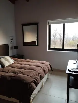 a bedroom with a bed and a mirror on the wall at Paraíso Serrano 18 in Villa Ciudad Parque