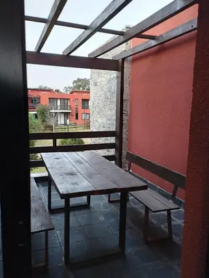 a wooden table and two benches on a balcony at Paraíso Serrano 18 in Villa Ciudad Parque