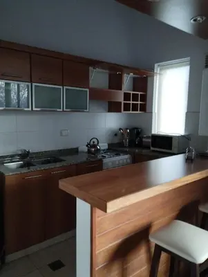 a kitchen with wooden cabinets and a wooden counter top at Paraíso Serrano 18 in Villa Ciudad Parque