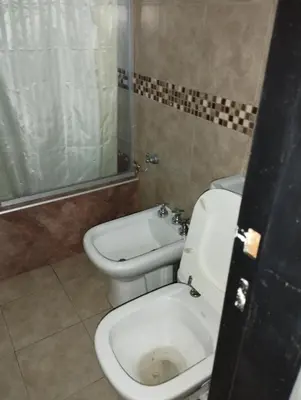 a bathroom with a white toilet and a shower at Paraíso Serrano 18 in Villa Ciudad Parque