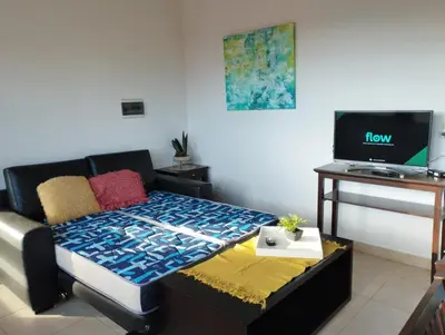 a living room with a bed and a television at Paraíso Serrano 18 in Villa Ciudad Parque