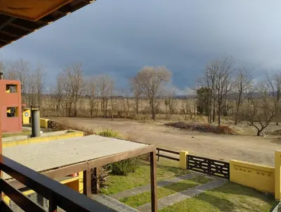 a picnic table on a porch with a view of a road at Paraíso Serrano 18 in Villa Ciudad Parque