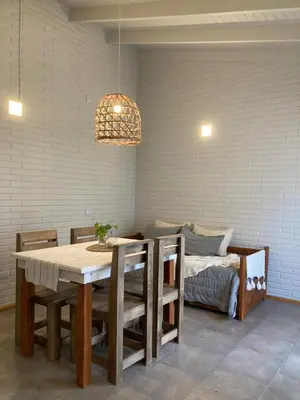 a dining room with a table and chairs and a couch at Cabañas Amapolas Los Reartes in Los Reartes