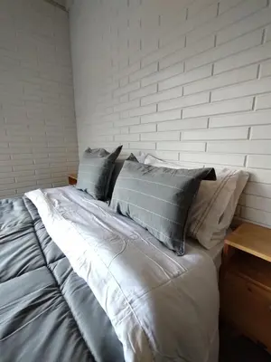 a bed with four pillows on top of it at Cabañas Amapolas Los Reartes in Los Reartes