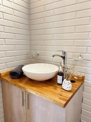 a bathroom with a white sink on a wooden counter at Cabañas Amapolas Los Reartes in Los Reartes