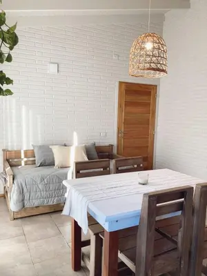 a living room with a table and a couch at Cabañas Amapolas Los Reartes in Los Reartes