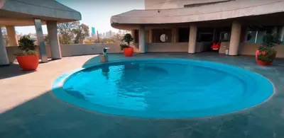 a large blue swimming pool in front of a building at Sonoma Ribera 5D in Cordoba