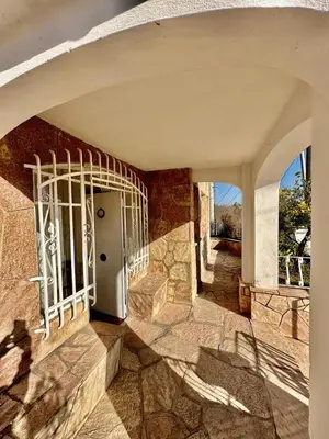 an entrance to a stone building with a white gate at La Soñada in Alta Gracia