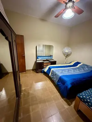 a bedroom with a blue bed and a ceiling fan at La Soñada in Alta Gracia