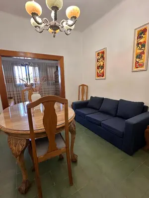 a living room with a table and a blue couch at La Soñada in Alta Gracia