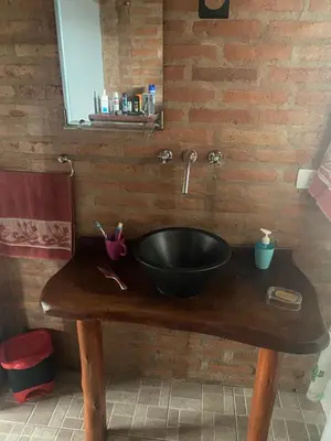 a bathroom sink with a black bowl on a wooden table at La Herminda Casas de Campo in Nono