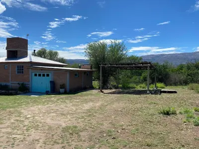 an old brick building with a gate in a field at La Herminda Casas de Campo in Nono