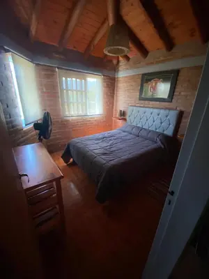 a bedroom with a bed and a table in a room at La Herminda Casas de Campo in Nono