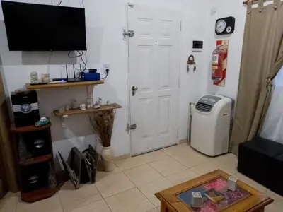 a living room with a television and a refrigerator at Cabañas La Enriqueta in Villa Carlos Paz