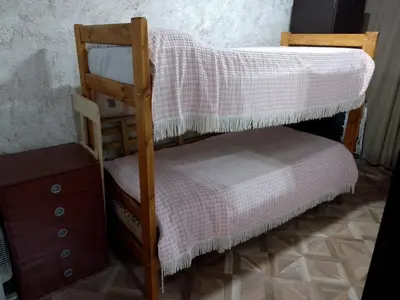 a bunk bed with a chair and a dresser at Cabañas La Enriqueta in Villa Carlos Paz