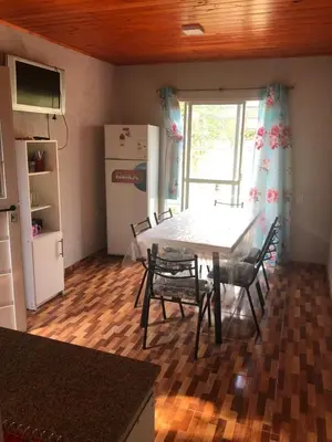a kitchen with a table and chairs and a refrigerator at Genesis Paz y Montaña Mallin Tanti in Tanti