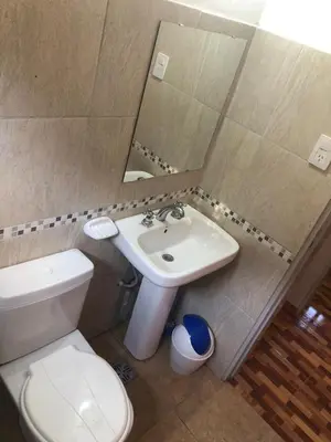 a bathroom with a white toilet and a sink at Genesis Paz y Montaña Mallin Tanti in Tanti