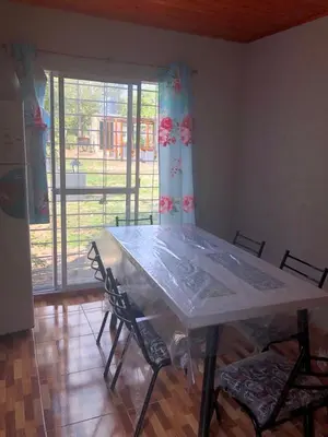 a dining room table with chairs and a large window at Genesis Paz y Montaña Mallin Tanti in Tanti