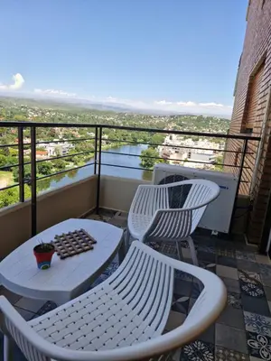 two chairs and a table on a balcony with a view at Departamento Acuario II - a metros del shopping woo in Villa Carlos Paz