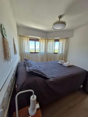 a bedroom with a large bed with a blue blanket at Departamento Acuario II - a metros del shopping woo in Villa Carlos Paz