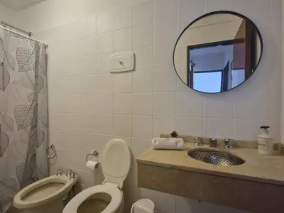 a bathroom with a toilet and a sink and a mirror at Departamento Acuario II - a metros del shopping woo in Villa Carlos Paz