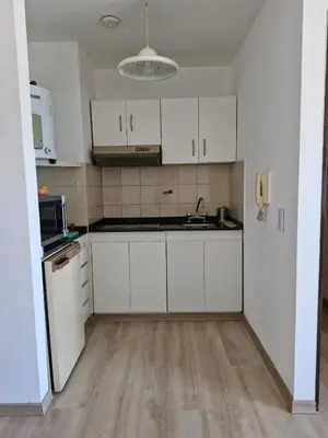 an empty kitchen with white cabinets and a sink at Departamento Acuario II - a metros del shopping woo in Villa Carlos Paz