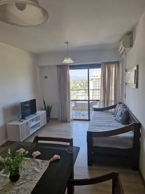a living room with a bed and a dining room table at Departamento Acuario II - a metros del shopping woo in Villa Carlos Paz