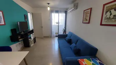 a living room with a blue couch and a television at Cañada in Cordoba