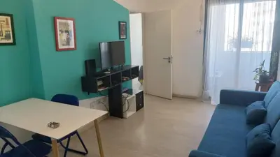 a living room with a blue couch and a table at Cañada in Cordoba