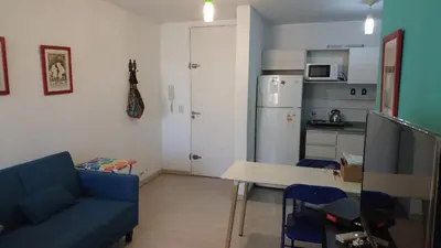 a living room with a blue couch and a table at Cañada in Cordoba