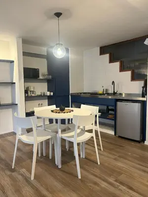 a kitchen with a white table and chairs in a room at Departamento Blue - Piso 1 Laprida Once in Cordoba