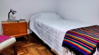 a bedroom with a bed and a dresser with a lamp at Habitación silenciosa Nº2 en Dpto Compartido in Cordoba