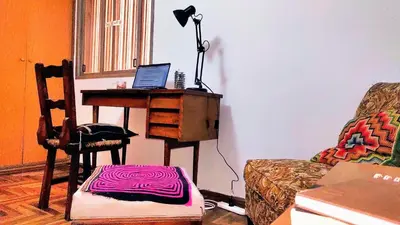 a living room with a desk with a laptop on it at Habitación silenciosa Nº2 en Dpto Compartido in Cordoba