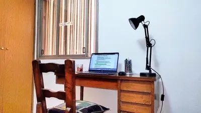 a laptop computer sitting on a desk with a lamp at Habitación silenciosa Nº2 en Dpto Compartido in Cordoba