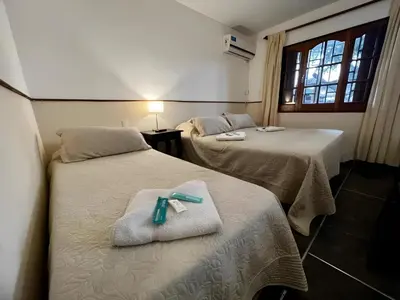 a room with two beds with a ribbon on them at Hotel Carlos Paz Centro - MONTECATINI in Villa Carlos Paz