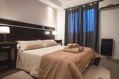 a bedroom with a bed with a towel on it at Hotel Carlos Paz Centro - MONTECATINI in Villa Carlos Paz
