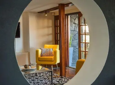 a living room with a yellow chair and a couch at Hotel Carlos Paz Centro - MONTECATINI in Villa Carlos Paz