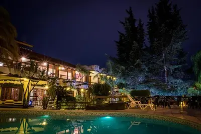 a resort with a swimming pool at night at Hotel Carlos Paz Centro - MONTECATINI in Villa Carlos Paz