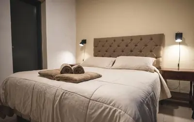 a bedroom with a large bed with two shoes on it at Hotel Carlos Paz Centro - MONTECATINI in Villa Carlos Paz