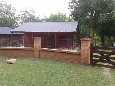 a building with a fence and a gate in a yard at Cabaña NANO in Tanti