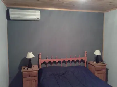 a bedroom with a bed and two night stands with lamps at Cabaña NANO in Tanti