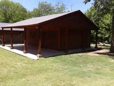 a wooden building with a roof on the grass at Cabaña NANO in Tanti