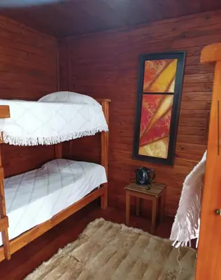 a bedroom with two bunk beds and a table at Kapo TEAM , colibri in Villa Amancay