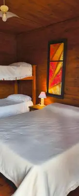a bedroom with two beds and a painting on the wall at Kapo TEAM , colibri in Villa Amancay