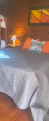 a large white bed in a wooden room at Kapo TEAM , colibri in Villa Amancay