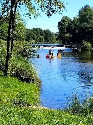 a group of people in a river with boats at Refugio del Rio in Los Reartes